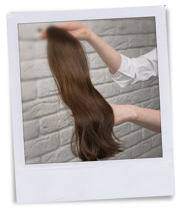 polaroid hands holding strand of hair